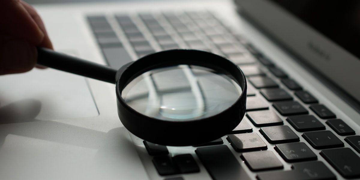 Lupa sobre laptop representando SEO e busca no Google